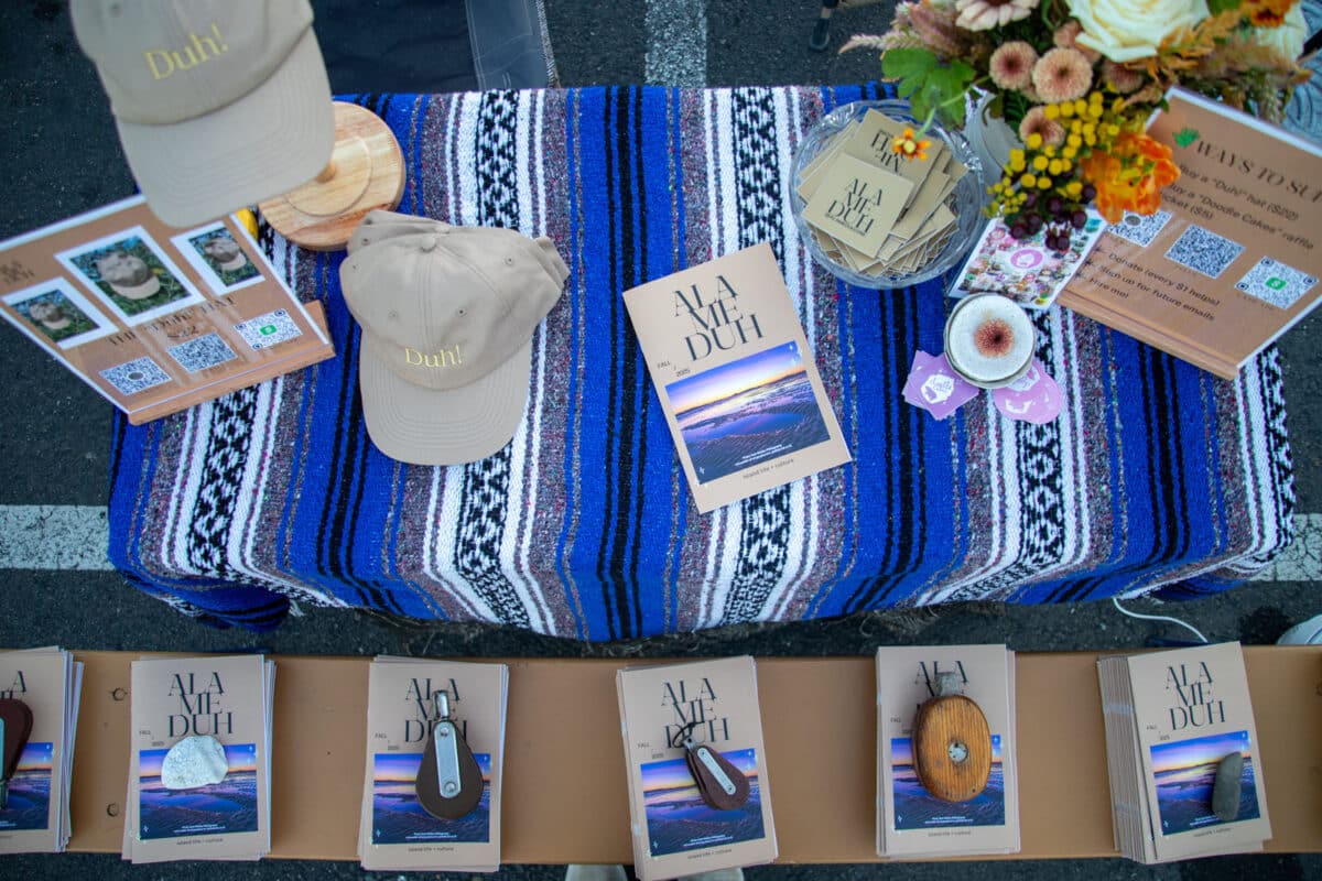 Alameda Post - Free copies of the Alameduh Zine are laid out artfully on a table. 