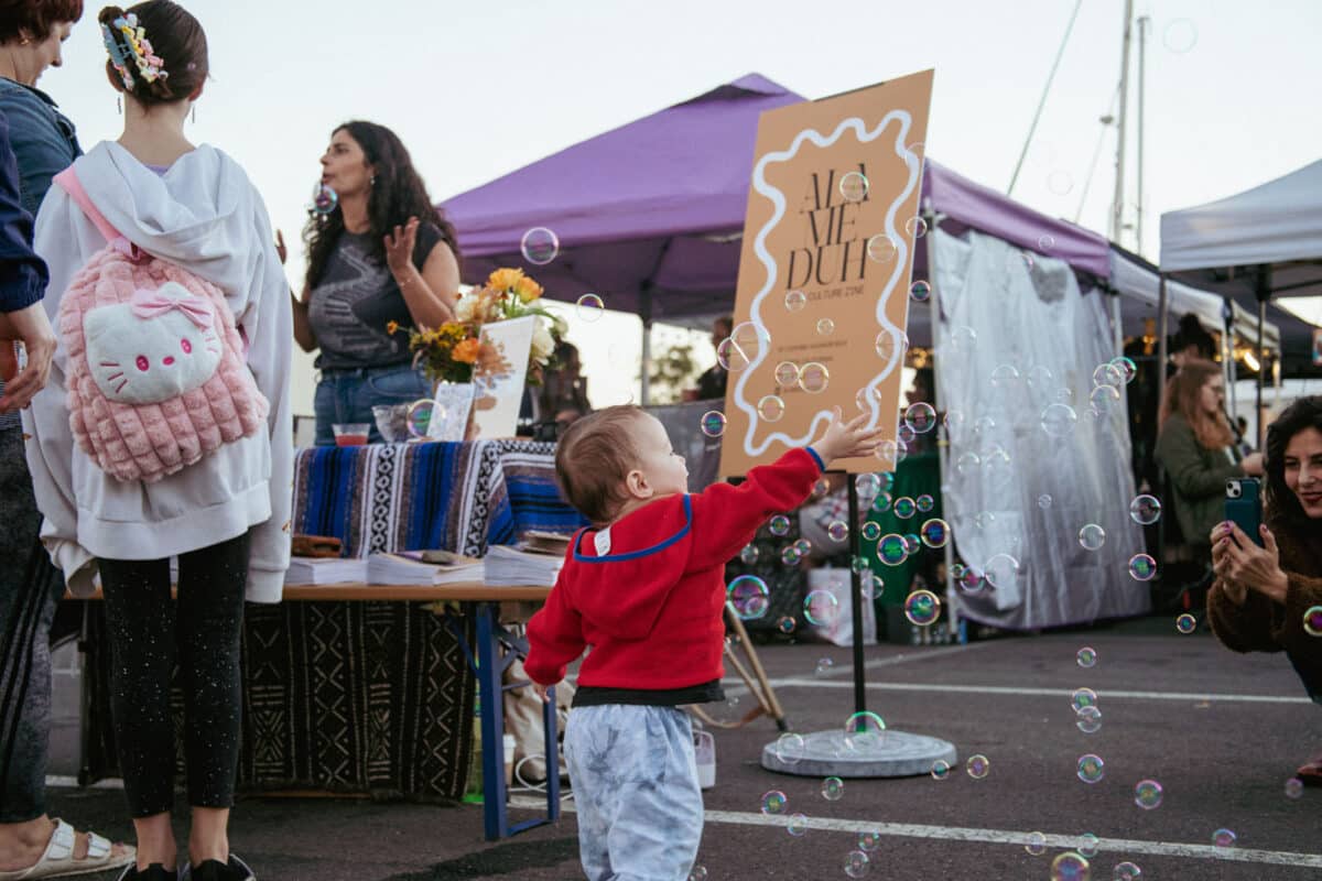 Alameda Post - A child reaches for bubbles at the Alameduh Zine launch party. 