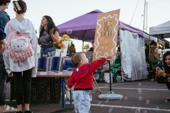 Alameda Post - A child reaches for bubbles at the Alameduh Zine launch party.