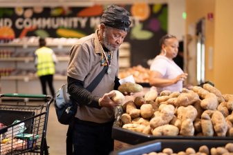 Alameda Post - An Alameda Food Bank shopper picks out potatoes.