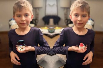 Alameda Post - A mirrored image of the same boy holding a cubical frosty the snowman and a spherical frosty the snowman.