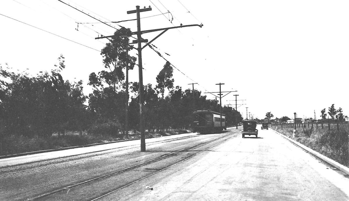 Alameda Post - a black and white photo of Fernside Boulevard with a car and an electric train system