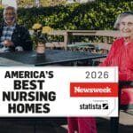 Alameda Post - Two residents of an AHS nursing home sit outside and smile at the camera. A banner on top reads "America's best nursing homes 2026."