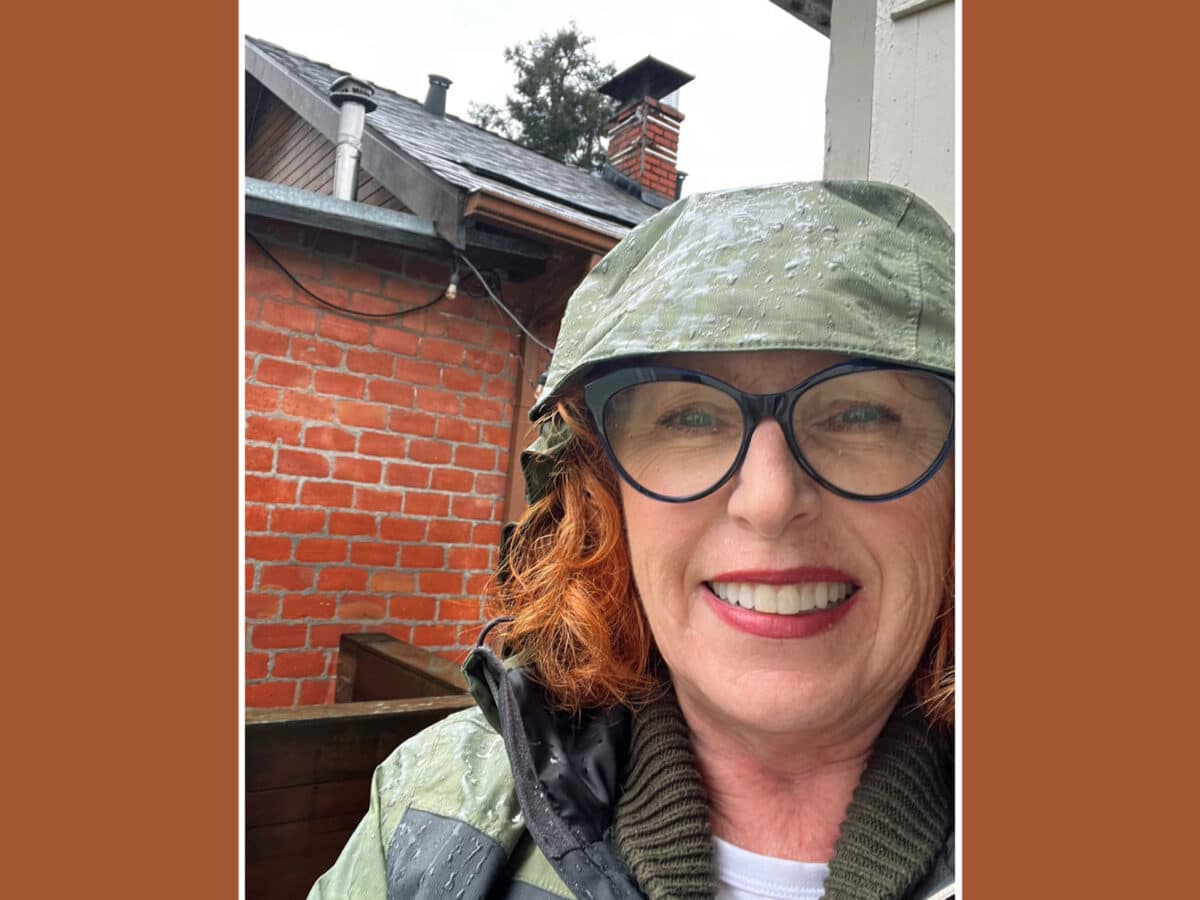 Alameda Post - Liz Rush smiles while wearing a rain jacket on a rainy day.