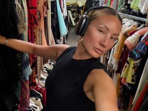 Alameda post - Miyako Bellizi takes a selfie while looking through clothing racks.