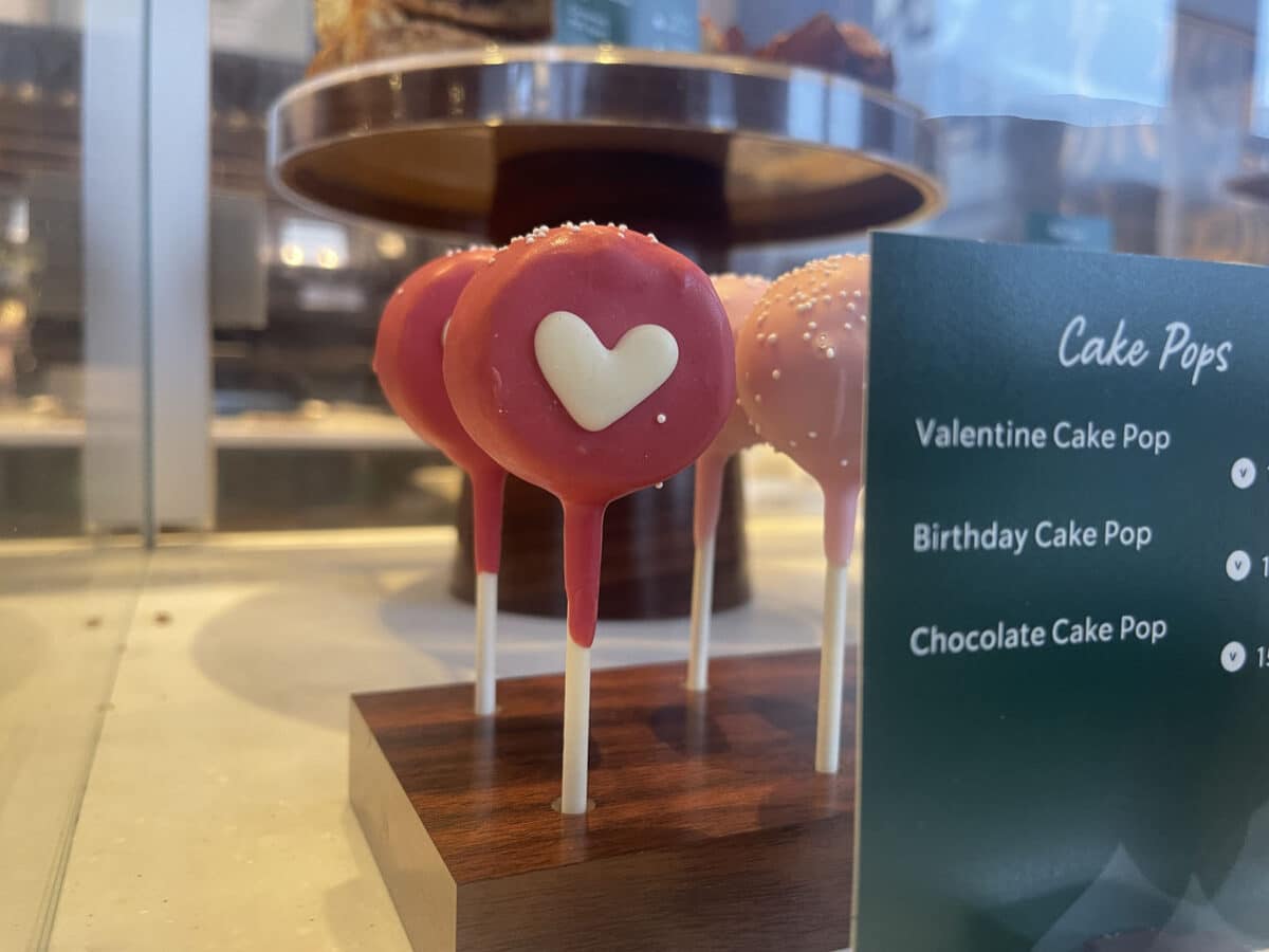 Alameda Post - Pink cake pops with white hearts in a display case.