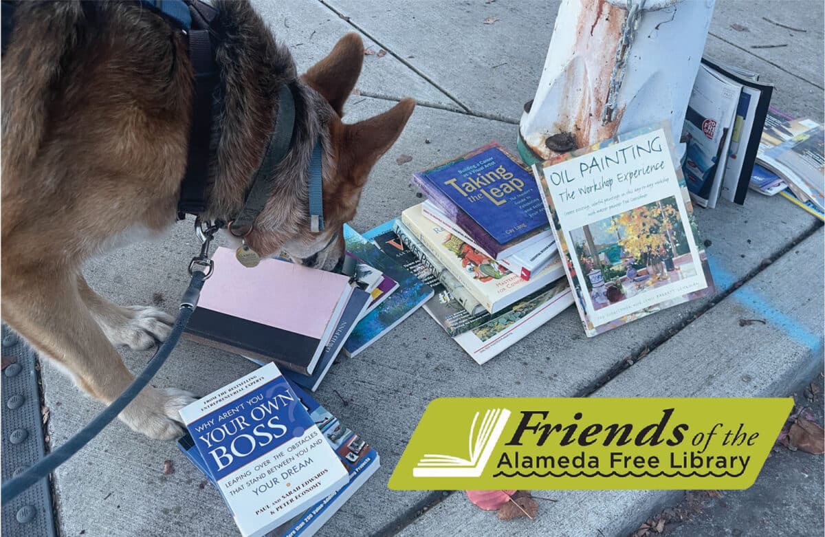 Alameda Post - Mouf sniffs a pile of books left out on the sidewalk. 