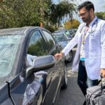 Alameda Post - an Alameda Health System doctor walking to their car with a doctor's bag