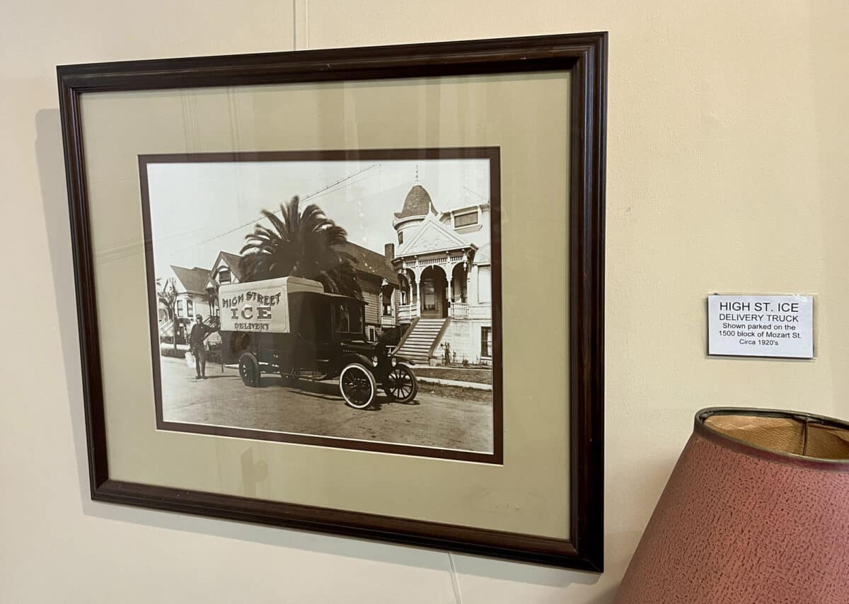 Alameda Post - A photograph hanging next to a museum plaque. The photograph is of an ice delivery truck in from of a home.