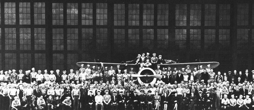 Alameda Post - a wide group photo at Alameda Point of assembly and repair workers with an aircraft