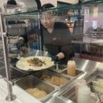 Alameda Post - behind the counter at Taco Fino, a worker prepares a burrito
