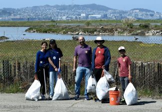 Alameda Post - five volunteers hold trash bags and smile