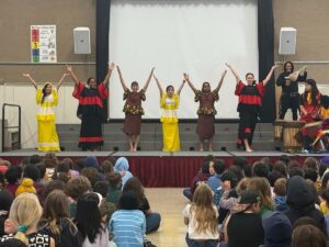 Alameda Post - Otis Elementary students sit in an auditorium and watch a African Diaspora Dance and Drum class perform onstage.