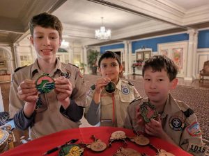 Alameda Post - three Scouts stand in their uniforms posing with laser-cut ornaments