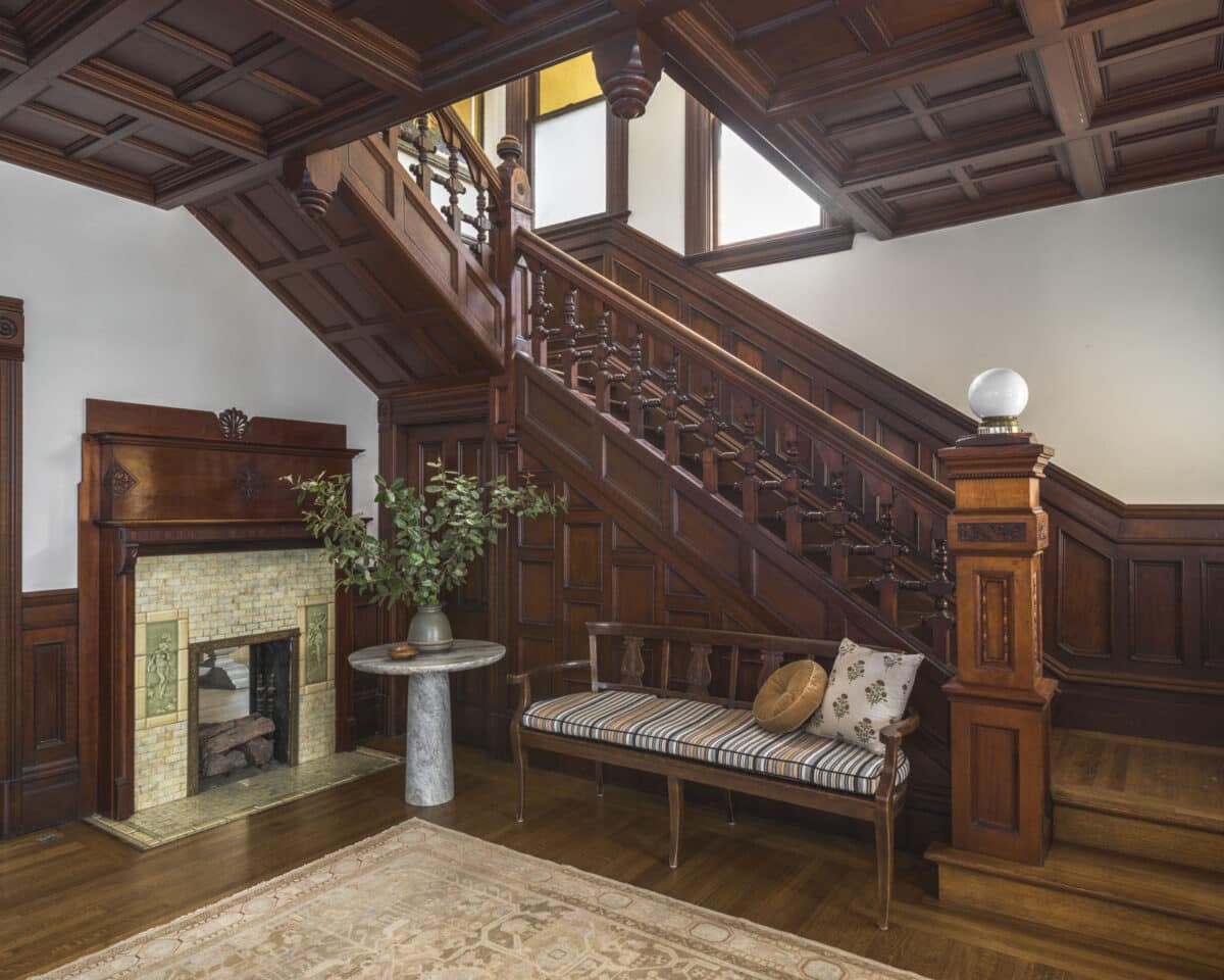 Alameda Post - a grand entryway and staircase at 899 Union Street with dark wood and a fireplace
