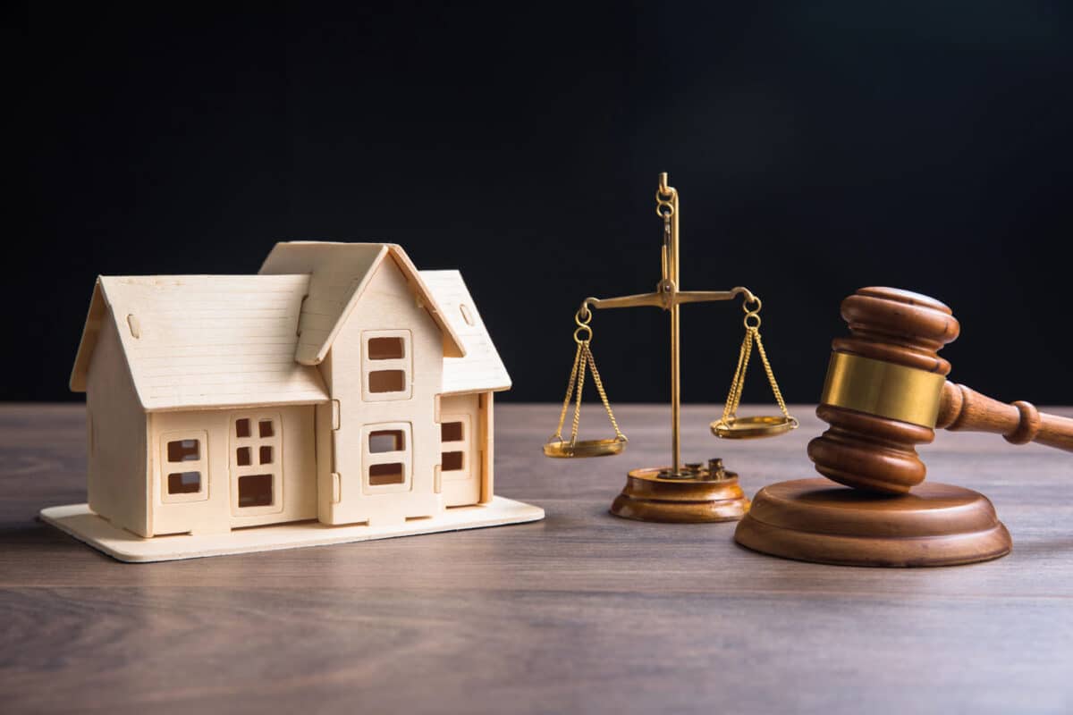 Alameda Post - A small model of a house, the scales of justice, and a gavel.