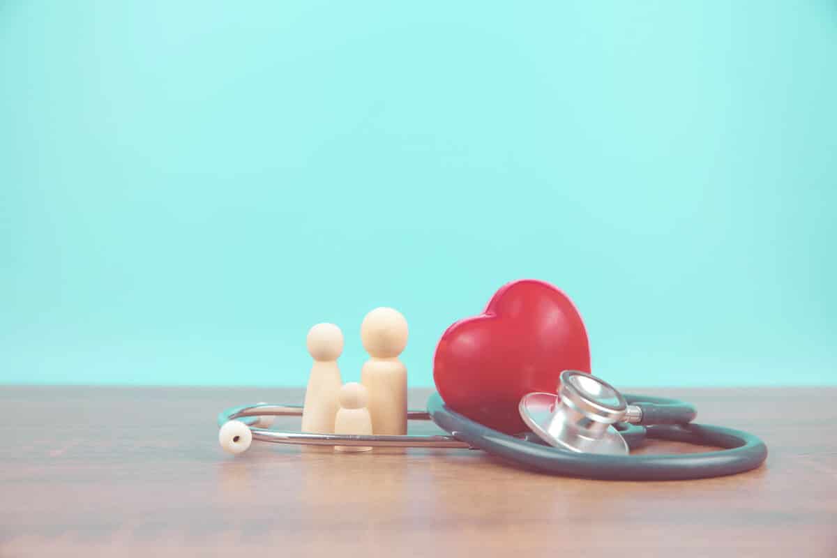 Alameda Post - a stock healthcare image of a small toy family surrounded by a stethoscope and heart