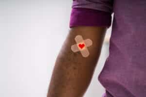 Alameda Post - An arm with a bandaid and a heart.