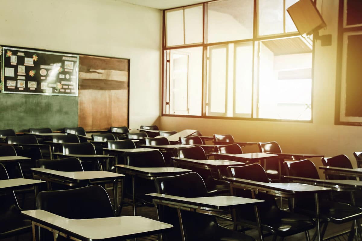 Alameda Post - an empty classroom is seen with light streaming in through the open windows. It appears to be late afternoon