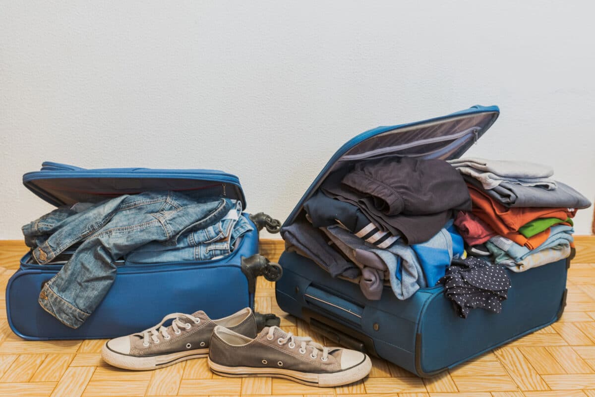 Alameda Post - Two overflowing suitcases and a pair of converse shoes.