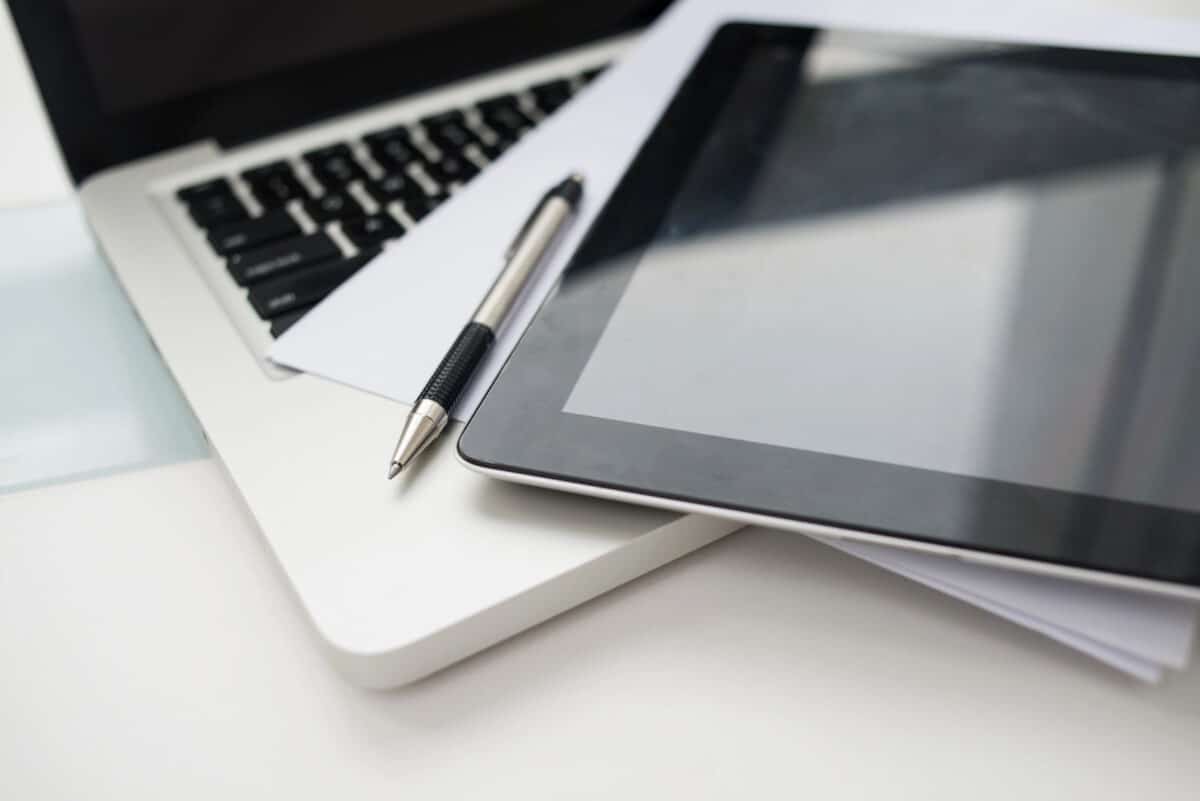 Alameda Post - A laptop, tablet, pen, and paper.