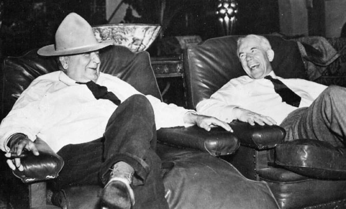 Alameda Post - two men sit next to each other on couches and laugh