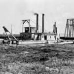 Alameda Post - a black and white photo of a dredge working on the waters around Alameda