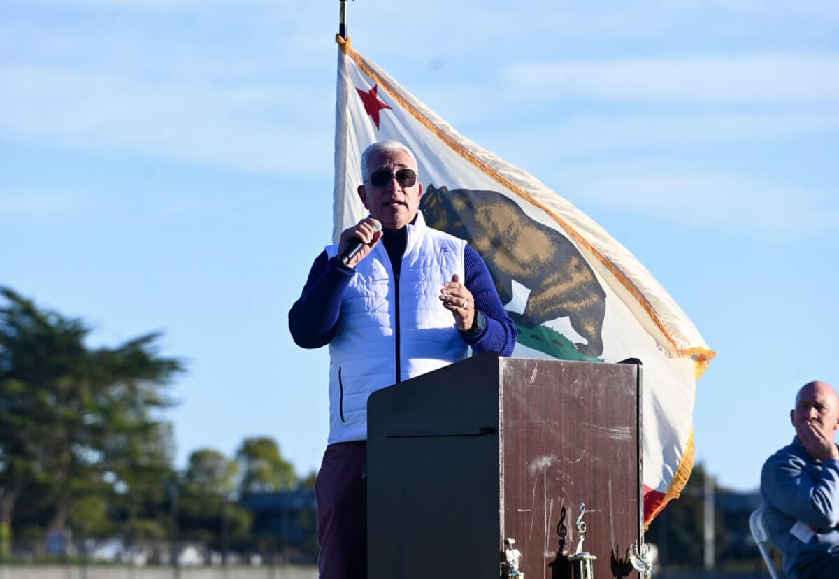 Alameda Post - Superintendent Pasquale Scuderi speaks into a microphone behind a podium outdoors at the new Enincal field. 
