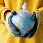 Alameda Post - a person holds a globe wrapped in plastic