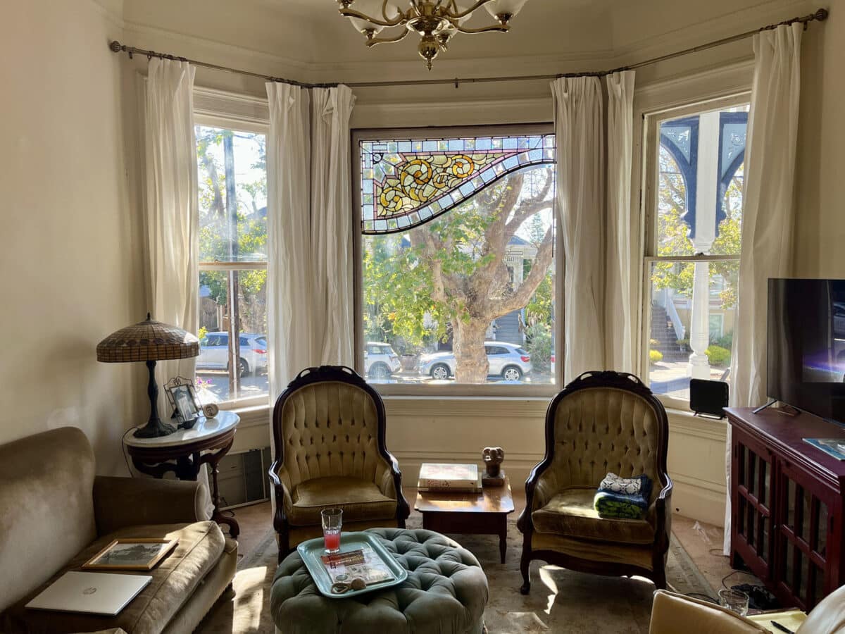 Alameda Post - A front parlor with beautiful large windows and stained glass.