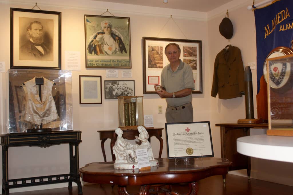 Alameda Post - George Gunn stands amongst historical photos, documents, and treasures at Alameda Museum