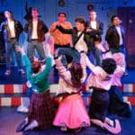 Alameda Post - In Altarena's Grease, female characters excitedly cheer for a musician and band on a platform onstage