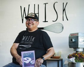 Alameda Post - Henry Awayan smiles at Whisk Bakery and holds his book, The Ube Baking Book.