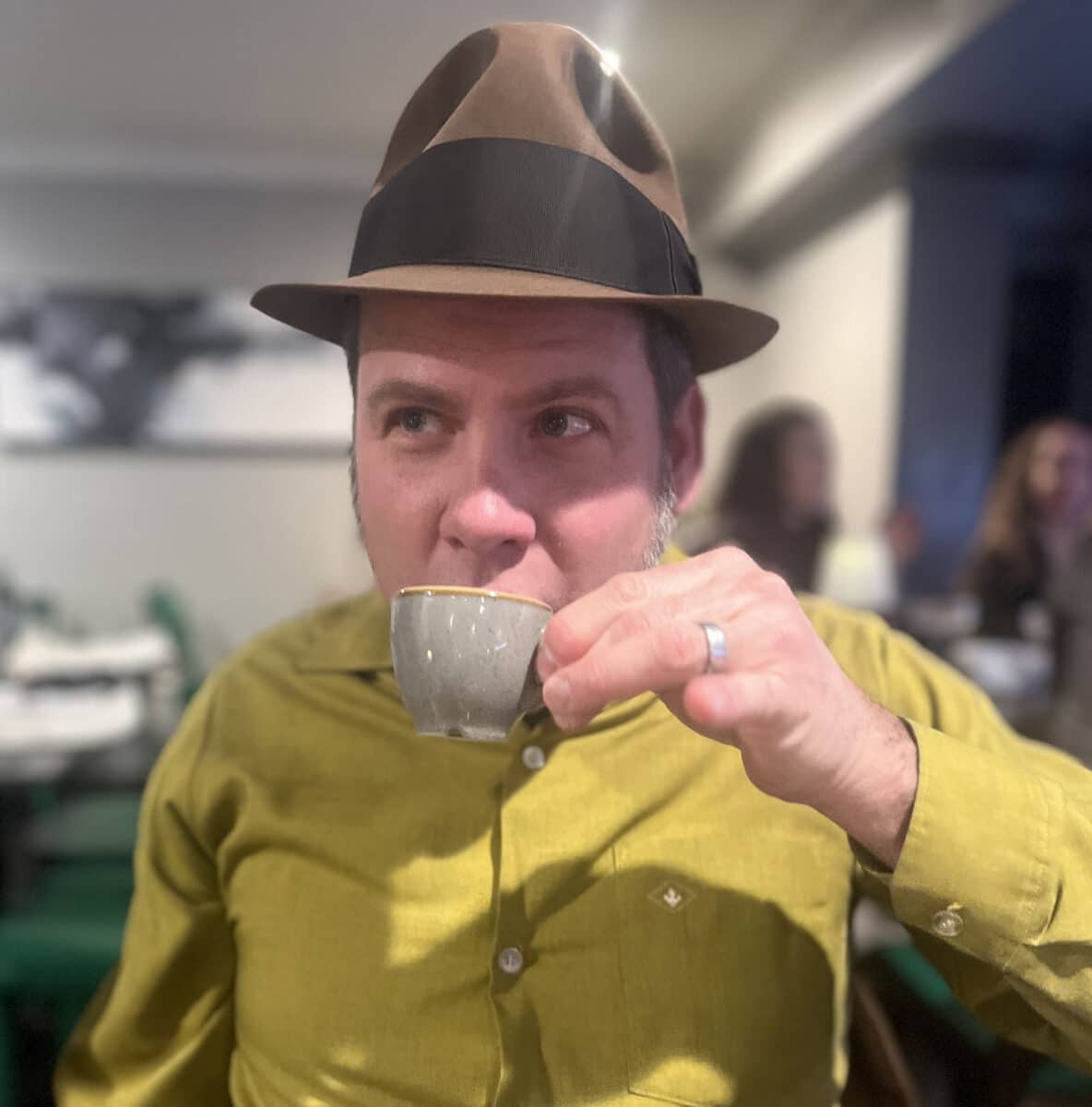 Alameda Post - Eric Schoeffler sips tea from a small teacup with his pinky out