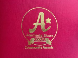Alameda Post - A golden embossed red piece of paper with the logo for Alameda Stars 2026.