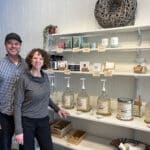 Alameda Post - the husband and wife team behind Replenish Marketplace stands with shelves of products, including large pump containers.