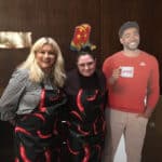 Alameda Post - two women wearing aprons with chilis on them stand net to a cardboard cutout of Jake from State Farm