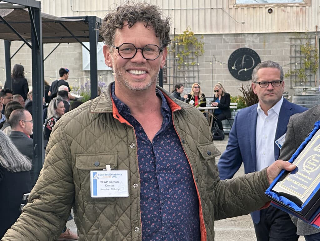 Alameda Post - a man smiles and holds a Business Excellence Award