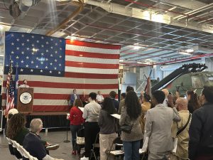 Alameda Post - new citizens raise their hands and take an oath during the naturalization ceremony on the USS Hornet