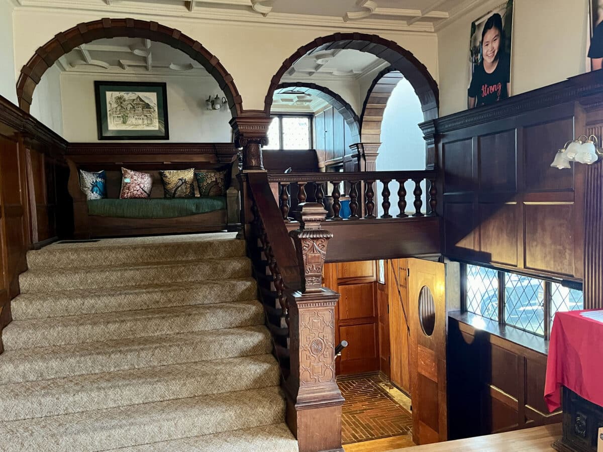 Alameda Post - The inside of an old home with lots of arches and beautiful dark wooden trim