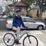 Alameda Post - a man smiles and poses with his bicycle