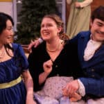 Alameda Post - three cast members sit together on a sofa, smile, laugh in their costumes