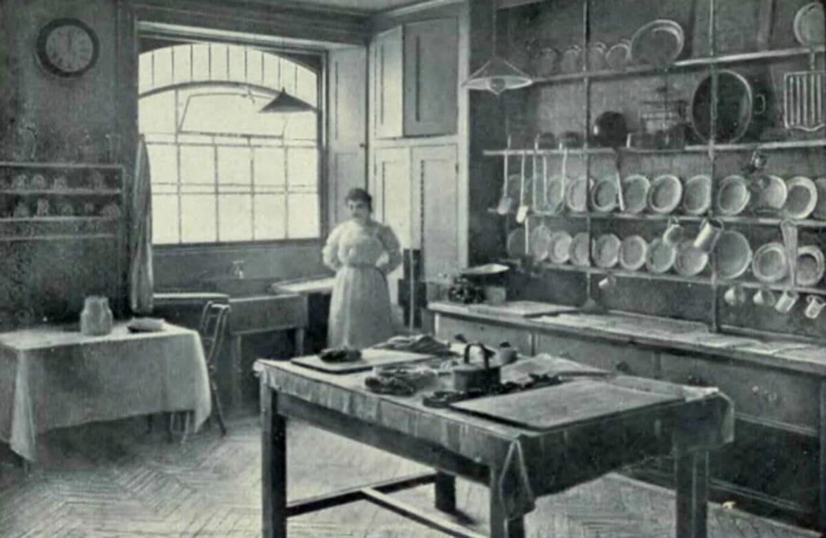 Alameda Post - a black and white photo or illustration of a woman in an old kitchen