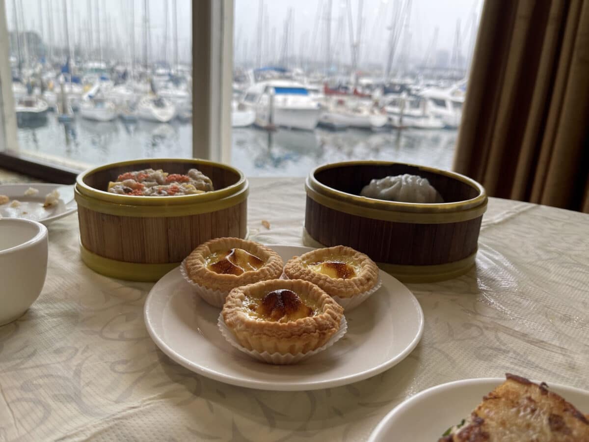 Alameda Post - small plates of food at a restaurant table with a view of a marina