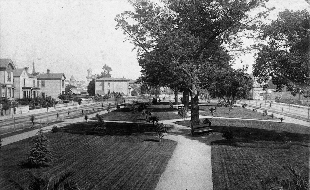 Alameda Post - a black and white photo of what is now Chochenyo Park. Landscaping, trees, and benches decorate the scene.