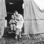 Alameda Post - a black and white photo of a father and son sitting together on a camping trip