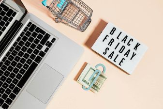 Alameda Post - a laptop, a mini shopping cart, a money clip, and a sign that says Black Friday Sale