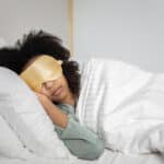 Alameda Post - a photo of someone in bed sleeping wearing a sleep mask