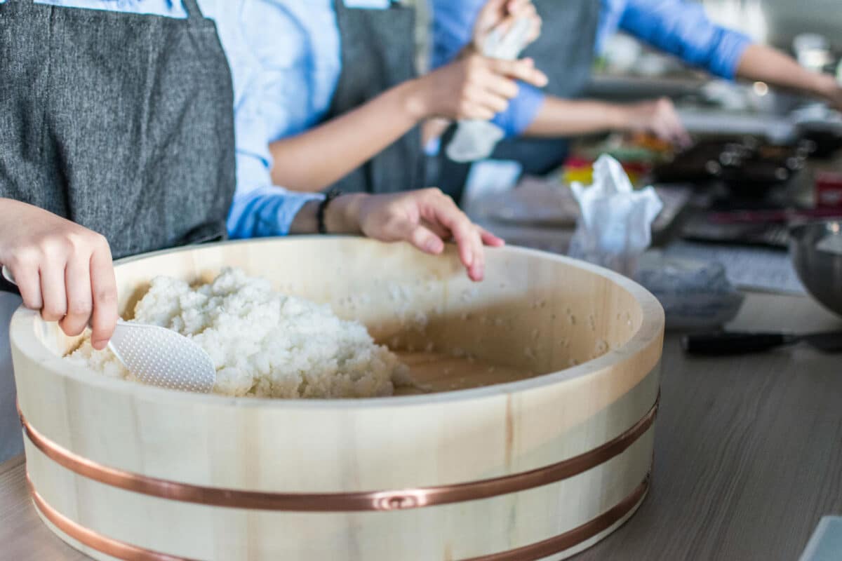 Alameda Post - someone scoops white rice with a paddle