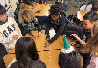 Alameda Post - A group of elementary students build a structure out of toothpicks or sticks on top of their desks.